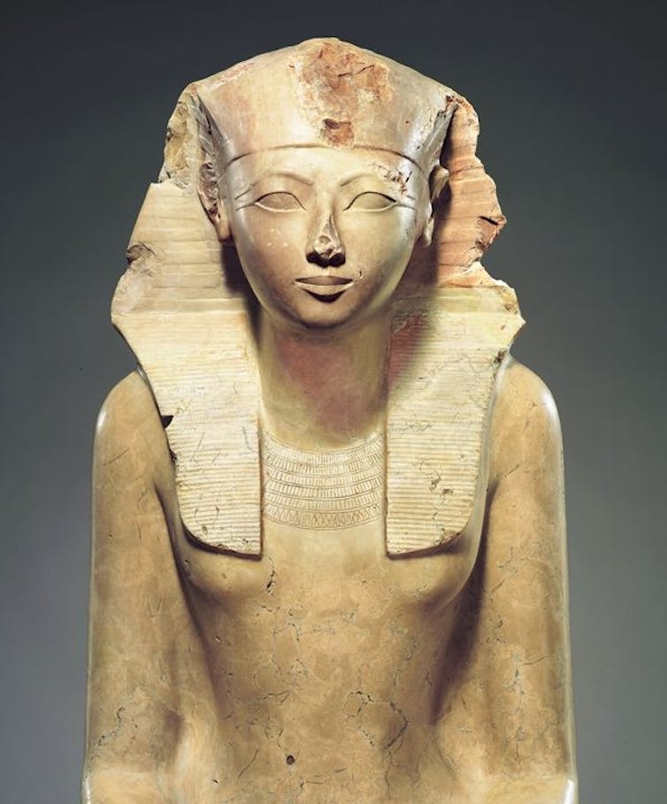 Uma estátua de arenito de Hatshepsut em um cocar de faraó.